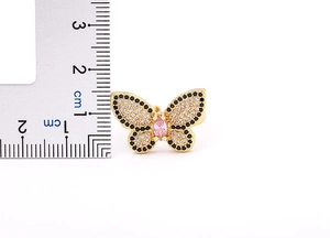 Macro shot of gold butterfly ring with pink and black stones showing size measurement