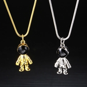 Detail of gold and silver astronaut pendants with enamel visors on snake chains
