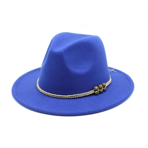Macro shot of royal blue fedora hat featuring a beige braided band and golden metal beads