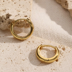 Minimalist S925 sterling silver hoop earrings in gold finish displayed on stone
