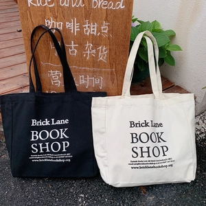 Detail of minimalist canvas tote bags with London bookstore print in black and off-white