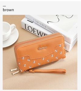 Brown long wallet with dual zippers and floral diamond pattern on lifestyle background