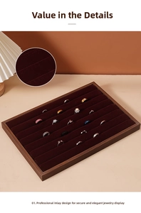 Detail of walnut wood jewelry tray with red velvet slots for rings and necklaces