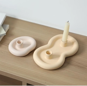 Detail of Nordic cloud ceramic candle holders in matte beige and pale yellow finish