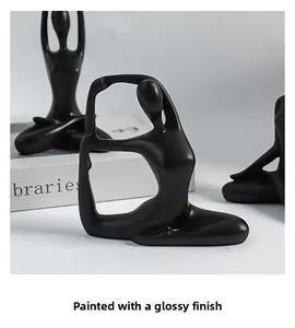 Detail of creative yoga girl sculpture showing matte black paint and abstract ceramic lines