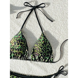 Flat lay of leopard print bikini set with green accents and adjustable black ties