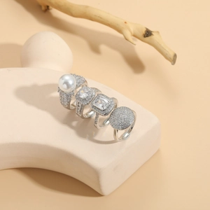 Detail of luxury ring set with pearl and zircon crystals on minimalist stone display