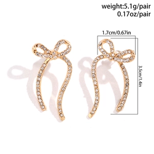 Detailed view of golden bow earrings with rhinestones showing size and weight specs