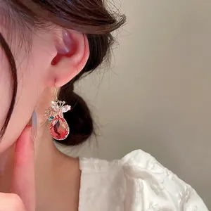 Boucles d'oreilles dorées avec cristal goutte rouge et papillon serti de zircons