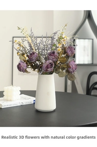 Close-up of vintage purple silk roses and chamomile in a white ceramic vase