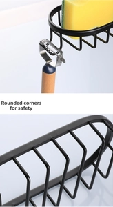 Detail view of black metal faucet rack holding sponge and peeler with smooth corners