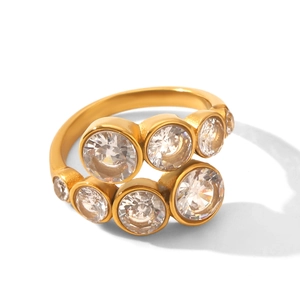 Dettaglio di un anello a spirale dorato con sette zirconi brillanti dal taglio rotondo