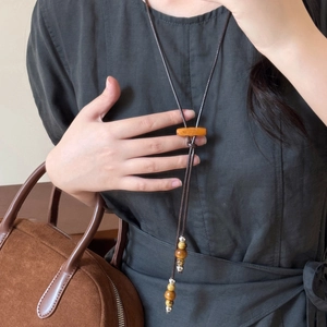 Long collier en cordon de cire style ethnique avec perles en bois et pendentif gland