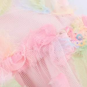 Close-up of pink and green mesh tulle dress with shimmering sequins and pleated ruffles