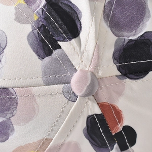 Macro shot of colorful watercolor print baseball cap top with stitching and center button