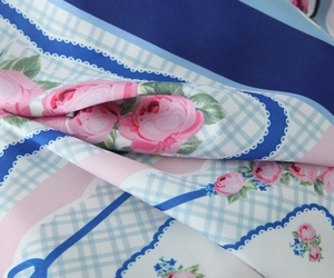 Gros plan sur un tissu en satin lisse avec imprimés roses et motifs à carreaux bleus