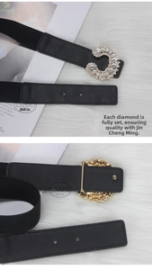 Detail view of black elastic belt with gold C-shape buckle and sparkling rhinestones
