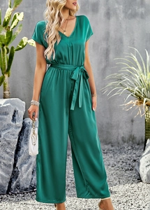 Detailed shot of green V-neck jumpsuit with short sleeves and a matching waist belt