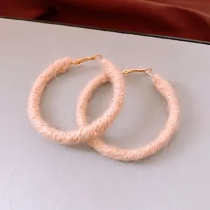 Handmade light pink wool-wrapped round hoop earrings with elegant gold metal hooks