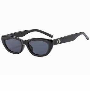 Detail of vintage cat eye sunglasses with high-gloss black frame and silver ring hinge