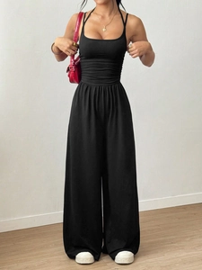 Detail of black strapless jumpsuit featuring a fitted bodice and wide-leg trousers design