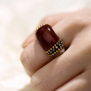 Detailed view of a vintage wide band ring featuring a large reddish-brown cat eye stone