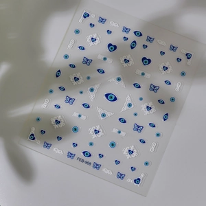 Detail of 5D embossed evil eye nail stickers with blue butterflies and floral lace