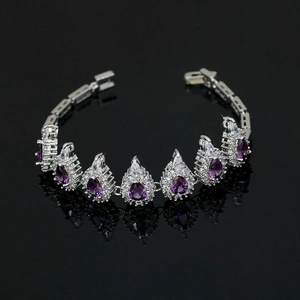 Detailed macro of silver-tone bracelet with purple teardrop gems and zircon halo
