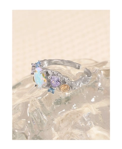 Macro shot of colorful zircon gems and textured silver band on crystalline surface