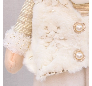 Detail of plush white faux fur vest with golden snowflake sequins and pearl button on toy