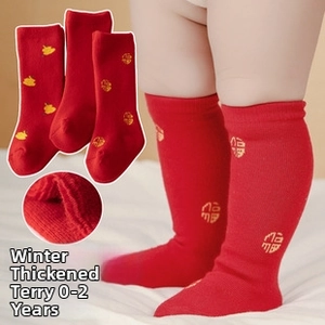 Detail view of thick red baby knee-high socks with golden festive embroidery and fleece lining