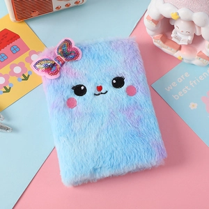 Dettaglio del taccuino in peluche blu e viola con fiocco di paillettes colorate e ricamo