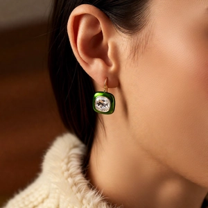 Close-up of model wearing green enamel square vintage earrings with 18k gold plating