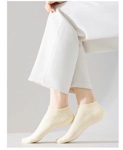 Detail of pale yellow ribbed cotton ankle socks with elastic cuff for a minimalist style