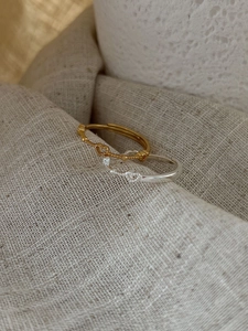 Macro detail of S925 sterling silver stamp on minimalist heart rings with bead accents