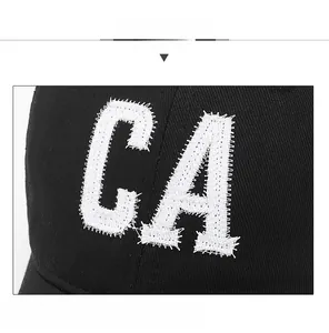 Détail de la broderie CA vintage sur casquette de baseball noire en coton avec bords usés