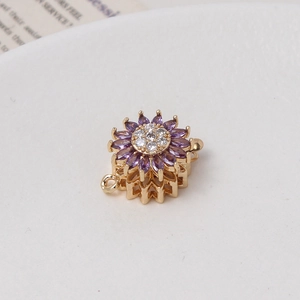 Macro detail of sun flower jewelry clasp with purple zircons and golden finish for DIY