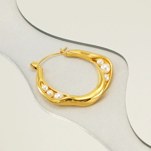 Detail of 18k gold irregular hoop earring with white pearls and push-back clasp