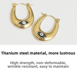 Detail of gold titanium steel U-shaped earrings with evil eye pattern and anti-deformation