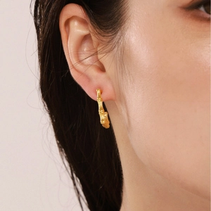 U-shaped bamboo design earrings in 18K gold plated stainless steel shown on model