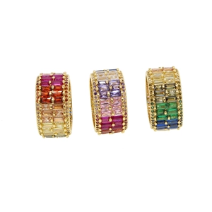 Three elegant gold rings with colorful gradient zircon pavé settings on white background