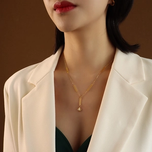 Elegant 18K gold-plated star pendant choker necklace on model with white blazer