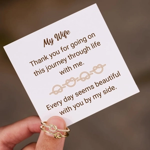 Close-up of golden s925 silver double knot rings with a romantic gift card for wife