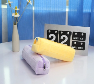 Detailed macro view of plush pencil cases with quilted pattern in yellow and purple