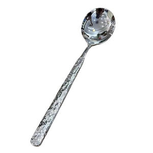 Polished stainless steel spoon with unique hammered stone texture handle for dining