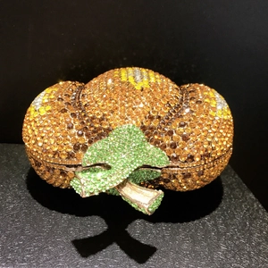 Dettaglio ravvicinato di una borsa a mano di lusso a forma di zucca con strass arancioni brillanti