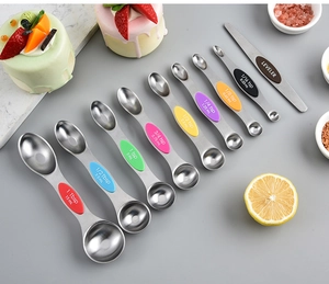 Detailed set of double-sided magnetic measuring spoons and leveler on baking background