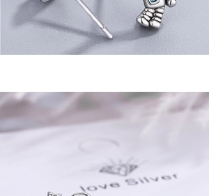 Macro detail of silver astronaut earring with blue accents and intricate textures