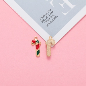 Detail of Christmas candy cane pendants with red and green enamel and golden texture