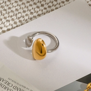 Detailed view of bicolor teardrop spheres on a polished stainless steel ring band